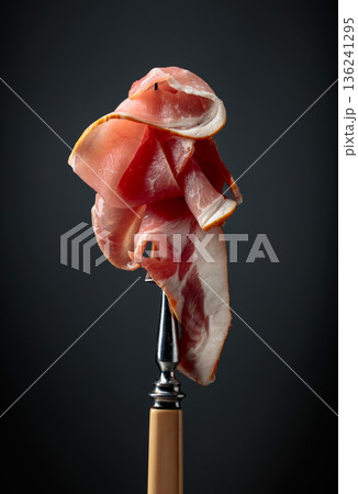 Raw fresh smoked pork bacon slices on a fork. Raw fresh smoked pork bacon slices on a fork. 136241295