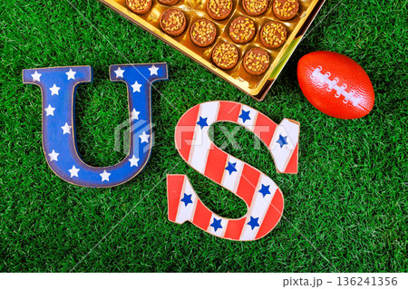 US letters are placed on green grass with small super bowl box of candy during sports event US letters are placed on green grass with small super bowl box of candy during sports event 136241356