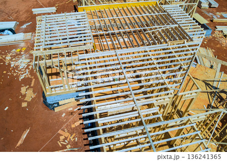 Workers build beams framing roof trusses with wooden frames materials on construction site 136241365