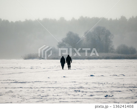 Two people walking in the snow Two people walking in the snow 136241408