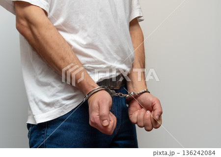 Man 45 years old standing in jeans with handcuffs on hands. Man 45 years old standing in jeans with handcuffs on hands. 136242084