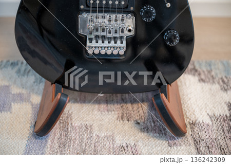 Electric guitar body detail with tremolo bridge on wooden stand 136242309