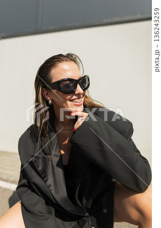 Stylish urban female portrait. Beautiful glamorous happy woman with smile with braces on teeth with sunglasses with blazer in city Stylish urban female portrait. Beautiful glamorous happy woman with smile with braces on teeth with sunglasses with blazer in city 136243259