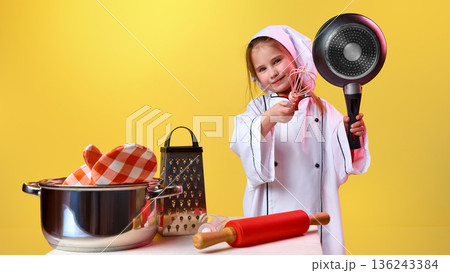 Young girl chef holding pan and whisk in studio Young girl chef holding pan and whisk in studio 136243384