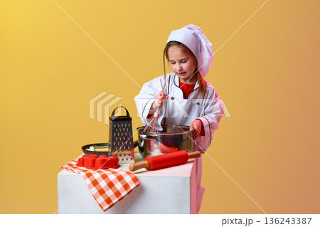 Young girl chef cooking with kitchen tools in studio. 136243387