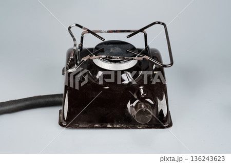 A dark brown single burner electric hot plate is positioned on a light gray surface 136243623