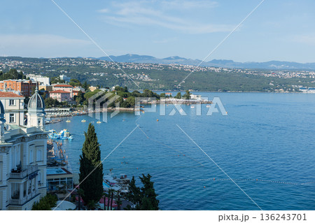 Coastal view of Opatija, Croatia with historic architecture, blue Adriatic Sea, beaches, and distant mountains. Popular Mediterranean travel and holiday destination. 136243701