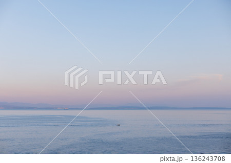Scenic seascape of Opatija, Croatia, city by the Adriatic Sea with distant hills and serene water. Opatija coastline in Croatia, tranquil sea horizon with city skyline and mountain backdrop at sunset 136243708