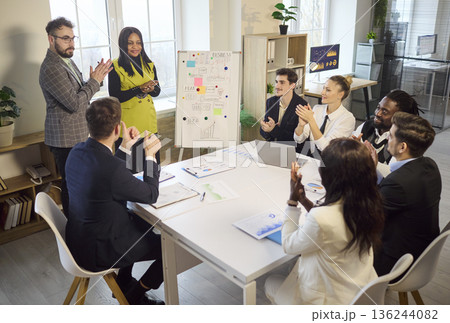 Office team applauding startup presentation during successful business meeting 136244082