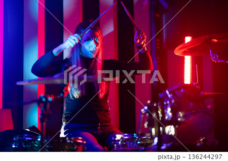 Female drummer playing drums during a live performance 136244297