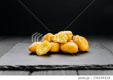 Crispy fried cheese balls with creamy filling on slate board, dark background with copy space 136244328