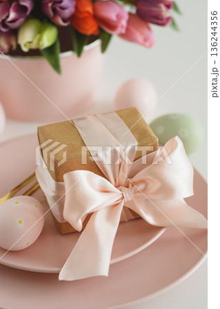 Easter Table Setting with Gift Box, Decorated Eggs and Tulips. Festive Spring Lifestyle Easter Table Setting with Gift Box, Decorated Eggs and Tulips. Festive Spring Lifestyle 136244356