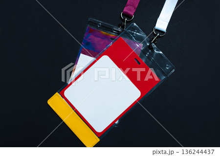 Blank identification badge in a plastic holder with red, white, and yellow colors, hanging on a lanyard. Concept of access, event pass, or personal credentials. Free copy space for design Blank identification badge in a plastic holder with red, white, and yellow colors, hanging on a lanyard. Concept of access, event pass, or personal credentials. Free copy space for design 136244437