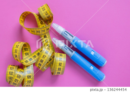 Flat lay of insulin pens and yellow tape measure. Concept image for health monitoring, diabetes control, and weight loss solutions. drugs injection ozempic for weight loss Flat lay of insulin pens and yellow tape measure. Concept image for health monitoring, diabetes control, and weight loss solutions. drugs injection ozempic for weight loss 136244454
