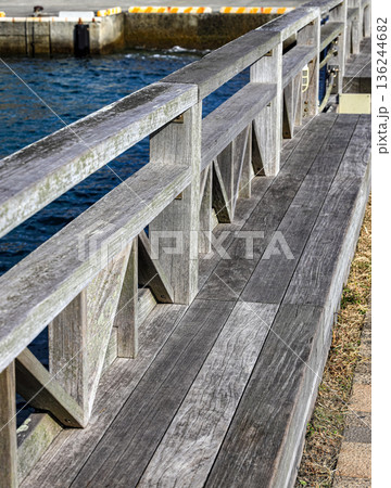 Wooden railing along the waterfront walkway. In the waterfront park. 136244682
