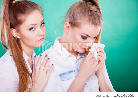 Sad woman crying and being consoled by friend. Sad woman crying and being consoled by friend. 136245659