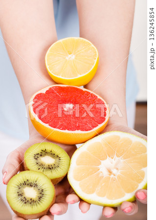 Woman holding fruits kiwi. orange, lemon and grapefruit Woman holding fruits kiwi. orange, lemon and grapefruit 136245854