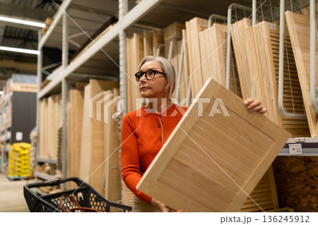 Woman shopping for wooden panels in a home improvement store during the daytime Woman shopping for wooden panels in a home improvement store during the daytime 136245912