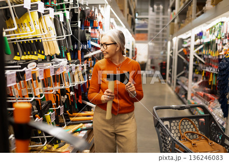 Senior woman shopping for tools in a home improvement store during the afternoon 136246083