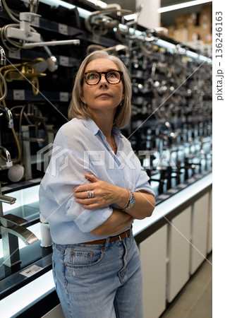 Stylish woman exploring modern kitchen fixtures in a home improvement store during a weekend visit 136246163