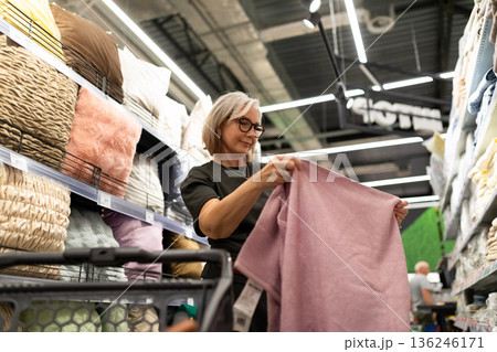 Woman shopping for soft textiles in a home goods store during a weekend afternoon Woman shopping for soft textiles in a home goods store during a weekend afternoon 136246171
