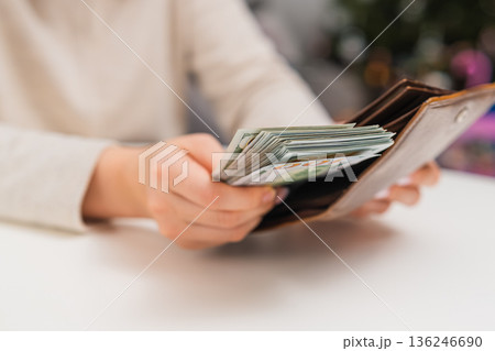 Female hands organizing cash money and saving dollars in wallet. Household budget and expense control. 136246690