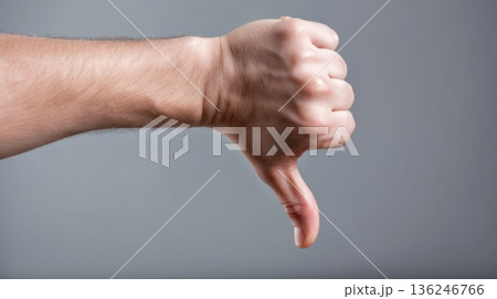 A hand with fingers curled and thumb pointing downward is presented against a plain gray background. The gesture clearly signals a negative response in a straightforward manner. 136246766