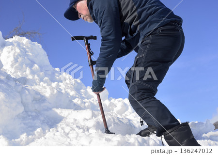 雪の階段を杖を使って上がり降りでリハビリをしている老人 雪の階段を杖を使って上がり降りでリハビリをしている老人 136247012