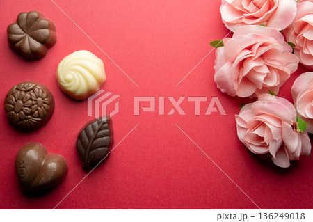 赤背景にチョコ菓子と装飾花を添えた構図 136249018