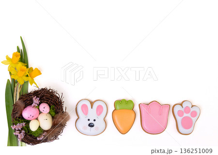 Gingerbread Easter cookies, nest with eggs and daffodils on white. 136251009