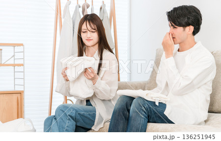 リビングで洗濯物を畳む夫婦,カップル(生乾き,生乾き臭,部屋干し) リビングで洗濯物を畳む夫婦,カップル(生乾き,生乾き臭,部屋干し) 136251945