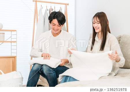 リビングで洗濯物を畳む笑顔の夫婦,カップル（家事参加,家事分担） 136251978