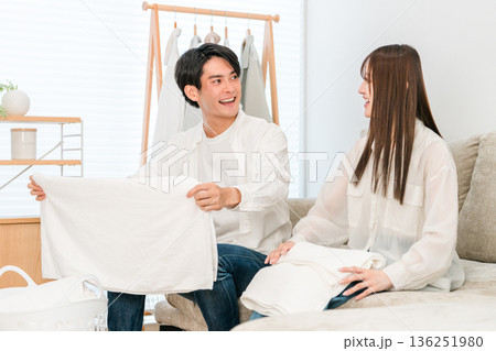 リビングで洗濯物を畳む笑顔の夫婦,カップル（家事参加,家事分担） 136251980