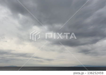 低い雲に覆われた静かな海の風景 136252459
