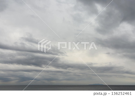 厚い雲が広がる灰色の空と静かな海 136252461