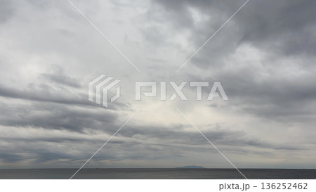厚い雲が広がる灰色の空と静かな海 136252462