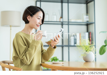 自宅でスマホを見るミドルの女性 自宅でスマホを見るミドルの女性 136252921