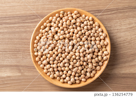 Top view of raw organic soybeans in a wooden bowl on a rustic wooden table Top view of raw organic soybeans in a wooden bowl on a rustic wooden table 136254779