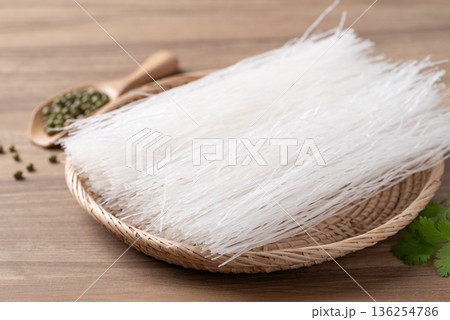 Dried glass noodles (Mung bean vermicelli) in a basket on wooden background, Thai food ingredients 136254786
