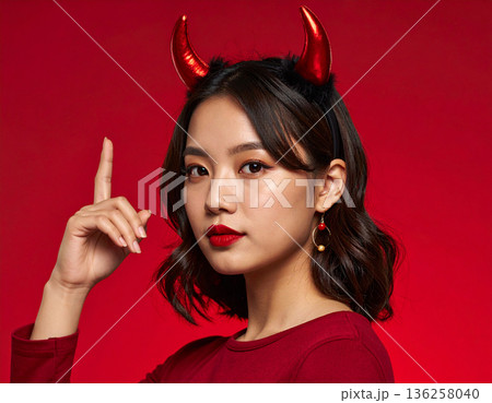 ハロウィンのコスプレで悪魔のツノをつけた若い女性 136258040