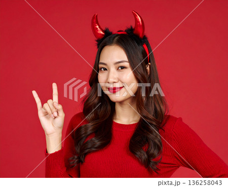 ハロウィンのコスプレで悪魔のツノをつけた若い女性 136258043