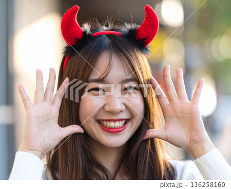 ハロウィンのコスプレで悪魔のツノをつけた若い女性 136258160
