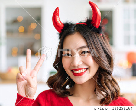ハロウィンのコスプレで悪魔のツノをつけた若い女性 136258164