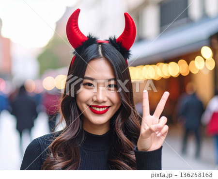 ハロウィンのコスプレで悪魔のツノをつけた若い女性 136258168