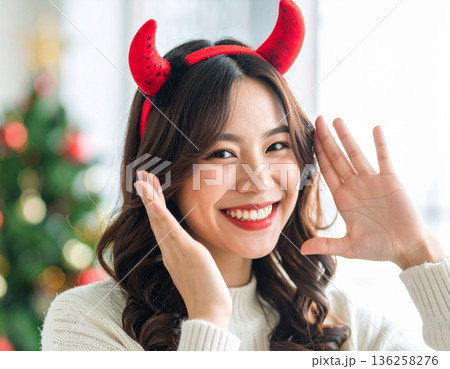 ハロウィンのコスプレで悪魔のツノをつけた若い女性 136258276