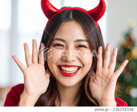 ハロウィンのコスプレで悪魔のツノをつけた若い女性 136258336
