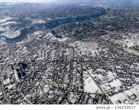 Aerial drone shot of a snow covered town with grid street layout 136259017