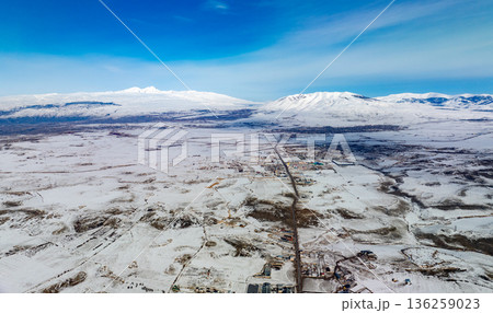 A snowy landscape with a road in the middle 136259023