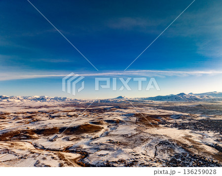 A clear blue sky with a few clouds and a snowy landscape A clear blue sky with a few clouds and a snowy landscape 136259028