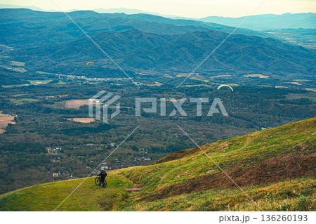 眼下を見下ろすマウンテンバイクとパラグライダー 136260193